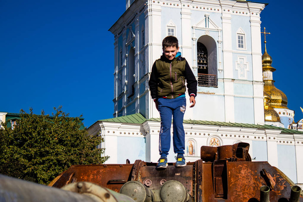 Vernietigde Russische militaire uitrusting tentoonstelling op Mykhailivska plein in Kiev in Oekraïne, 16 oktober 2022Oekraïense kinderen hebben plezier op de vernietigde Russische militaire uitrusting, ze gebruiken het als een speeltuin.  - Foto, afbeelding