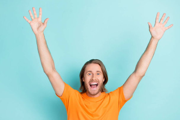 Photo of young handsome funny attractive guy wear orange t-shirt palms up happy worker finally weekend isolated on bright blue color background. - Fotoğraf, Görsel