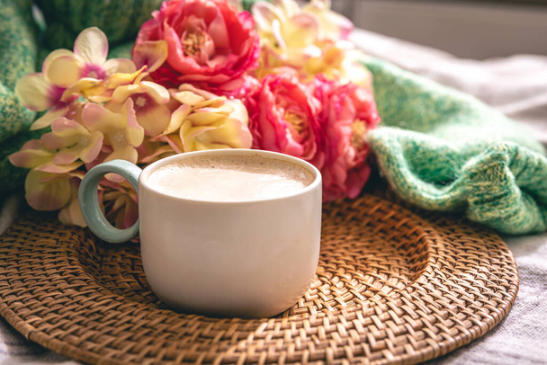 Cozy home composition with a cup of cappuccino, flowers and a knitted element. - Photo, Image