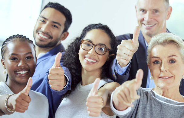Weve got whatever you need. a group of businesspeople showing a thumbs up at work - Foto, immagini