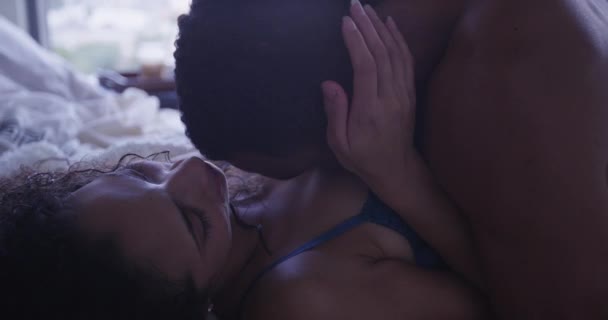 Langsam mo Nahaufnahme von intim liebenden Paar, das zusammen im Bett liegt, sich küssend und haltend - Filmmaterial, Video