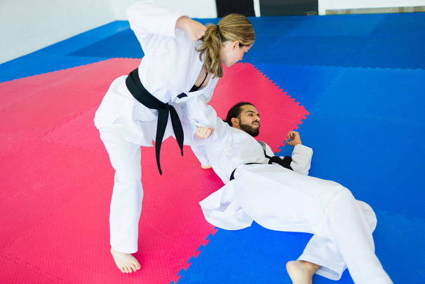 Sterke jonge vrouw vechten met een man vechter tijdens een taekwondo competitie  - Foto, afbeelding