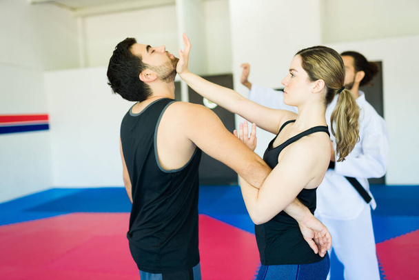 Attractive woman and young man fighting during a personal defense class  - Fotografie, Obrázek