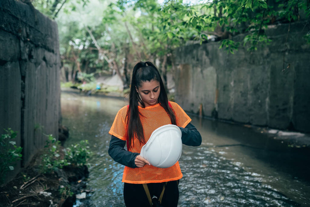 A young female digger walks along a rain collector - Foto, immagini