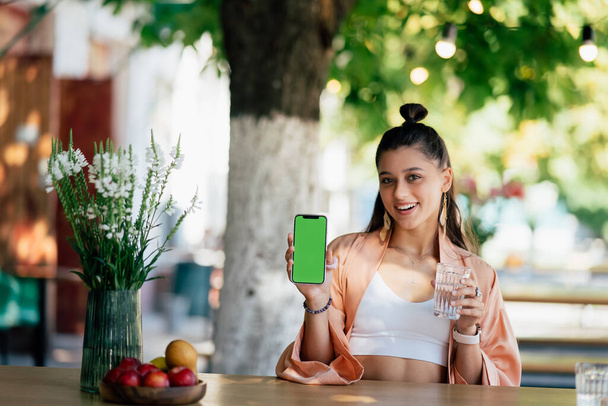 Happy woman hold smartphone. Green screen phone screen - Photo, Image
