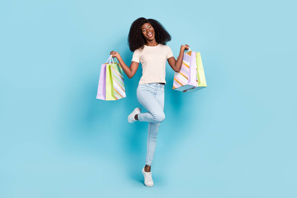 Full body portrait of cheerful overjoyed girl arms hold raise packages isolated on blue color background. - Foto, Bild