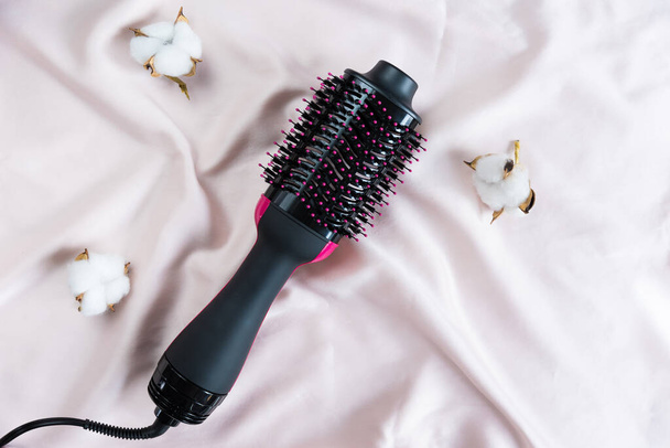 Secador de pelo eléctrico con cepillo reventador sobre fondo rosa - Foto, Imagen