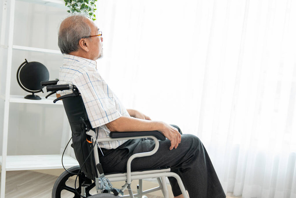 Portrait of a contented elderly man in sitting on a wheelchair at home. Senior person in nursing house service . - Photo, Image