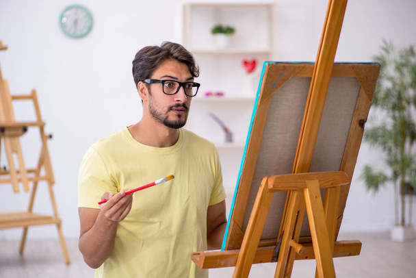 Jeune peintre masculin appréciant la peinture à la maison - Photo, image