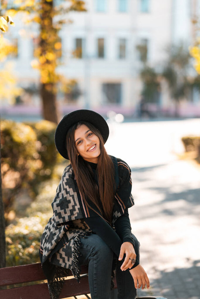 Mladá žena na lavičce v podzimním parku. Lidé, svoboda, životní styl, cestování a dovolená koncept. - Fotografie, Obrázek