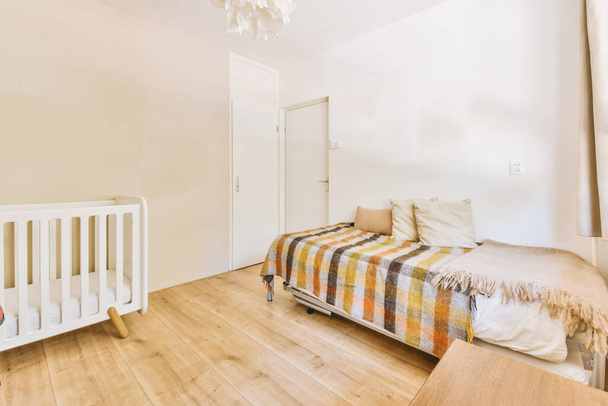 Home interior design della camera da letto con letto e armadio in legno collocato in angolo vicino alla finestra in appartamento moderno - Foto, immagini