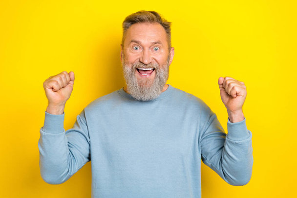 Portrait of delighted overjoyed person raise fists luck triumph attainment isolated on yellow color background - Foto, imagen