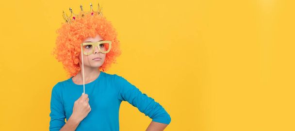 serious teen girl in fancy clown wig wear queen crown and funny party glasses, arrogant. Funny teenager child in wig, party poster. Banner header, copy space - Photo, Image