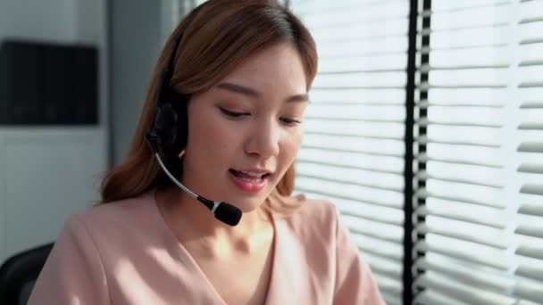 Competent female operator working on computer and while talking with clients. Concept relevant to both call centers and customer service offices. - Video