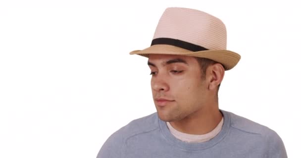 Gelukkige duizendjarige Spaanse gemengde ras man op witte achtergrond met hoed. Fashionable jonge Mexicaanse man in de twintig draagt fedora. Begrepen, ruimte. 4k - Video