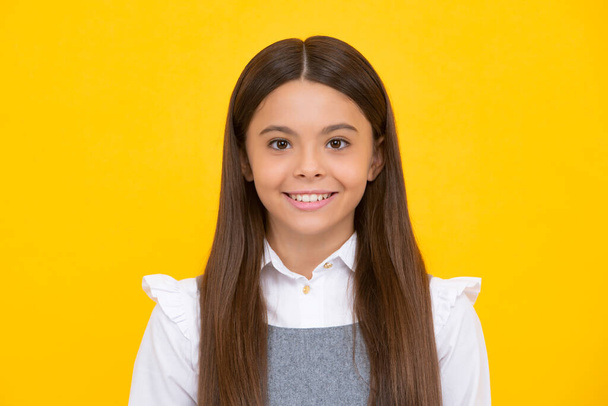 Happy girl face, positive and smiling emotions. Close up portrait of caucasian teen girl. Head shot of cute teenager child on yellow isolated studio background - Photo, Image
