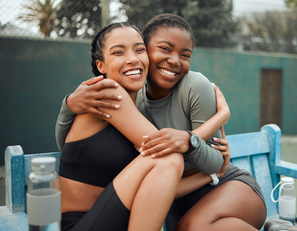 My favourite workout buddy. Cropped portrait of two attractive young female athletes embracing while sitting on a bench outside during their workout - Fotografie, Obrázek