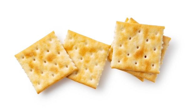Crackers posizionati uno sopra l'altro su uno sfondo bianco. Visto dall'alto. - Foto, immagini
