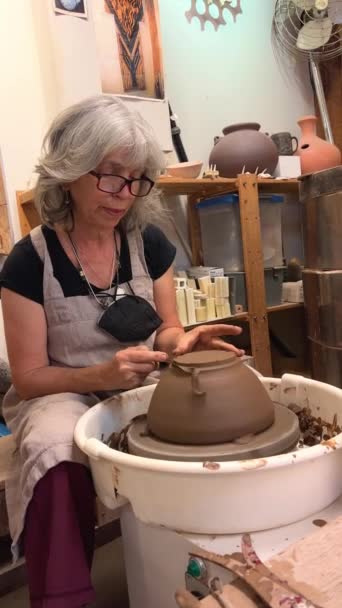 Primo piano di mani di vasai coperte di argilla che fanno il bel vaso su ruota di lancio in laboratorio di ceramica. Creatività e concetto artigianale tradizionale. Filmati 4k di alta qualità - Filmati, video