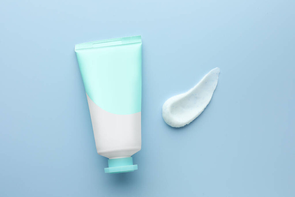 Sample of hand cream and tube on light blue background, top view - Фото, изображение