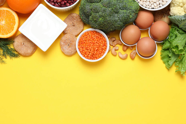 Food high in calcium. Flat lay composition with different products on yellow background, space for text - Photo, image