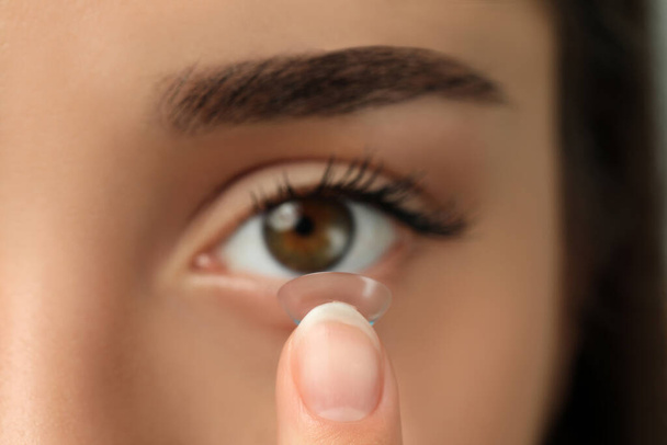 Woman putting contact lens in her eye, closeup view - Fotografie, Obrázek