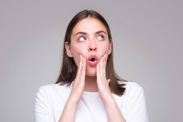 Shocked face of surprised young woman. Funny female shocked face expression. Unbelievable. Portrait of excited woman spreading hands. Expressing surprise open mouth. Emotional girl - Foto, imagen