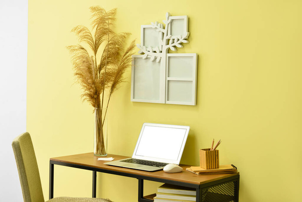 Interior acolhedor do local de trabalho moderno com laptop e árvore genealógica moldura - Foto, Imagem