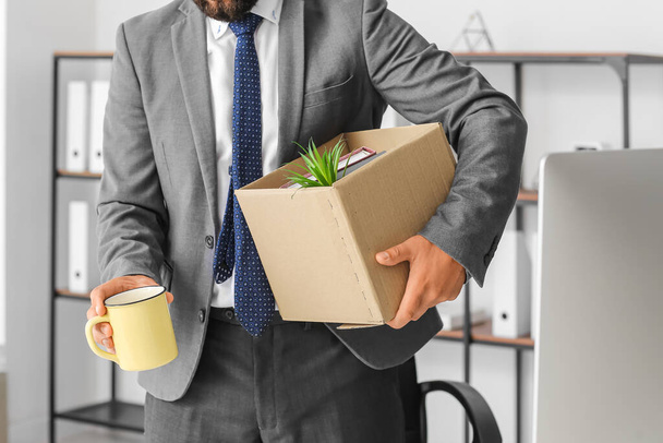 Fired young man holding box with his stuff in office - Photo, Image