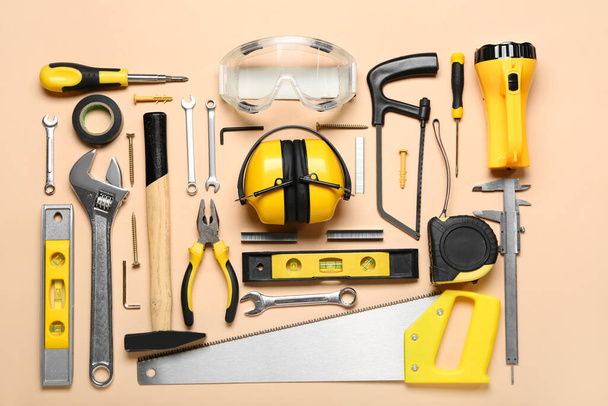 Builder's tools with hearing protectors on beige background - Foto, Imagen