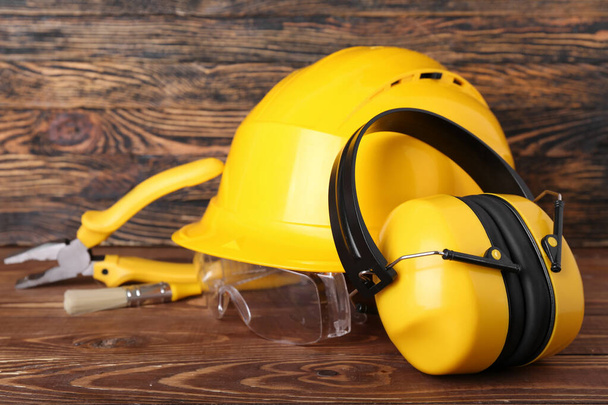 Protetores auditivos com ferramentas do construtor em fundo de madeira escura, close-up - Foto, Imagem