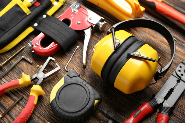 Hearing protectors with builder's tools on dark wooden background - Photo, Image