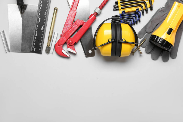 Protetores auditivos com ferramentas do construtor em fundo cinza - Foto, Imagem