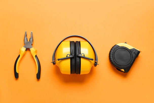 Інструменти та слухові протектори будівельника на кольоровому фоні
 - Фото, зображення