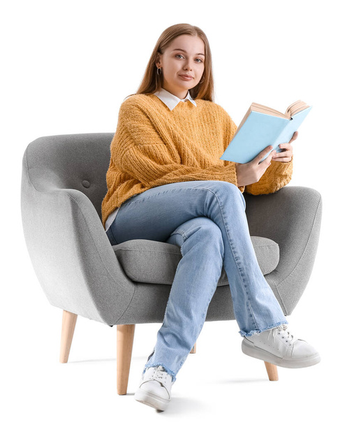 Young woman with book sitting in armchair on white background - Foto, immagini