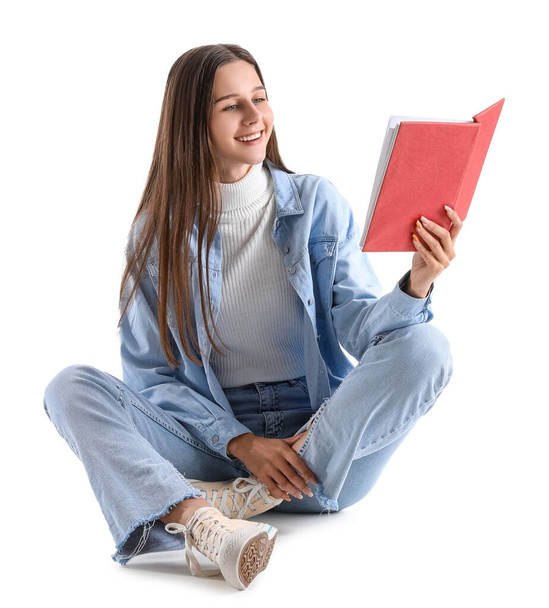 Schöne Frau in Jeansjacke liest Buch auf weißem Hintergrund - Foto, Bild