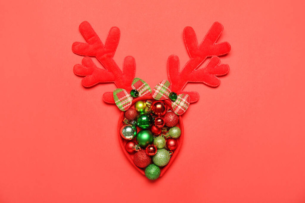 Christmas reindeer horns and balls on red background - Photo, Image