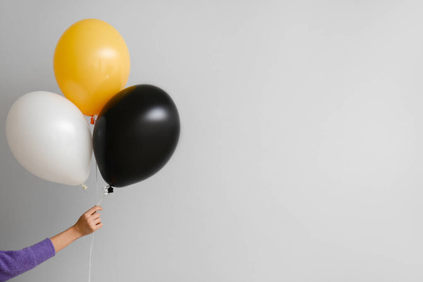Woman with Halloween balloons on grey background - Foto, immagini