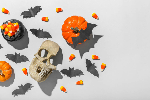 Morcegos de papel com abóboras de Halloween, milho doce e crânio no fundo cinza - Foto, Imagem