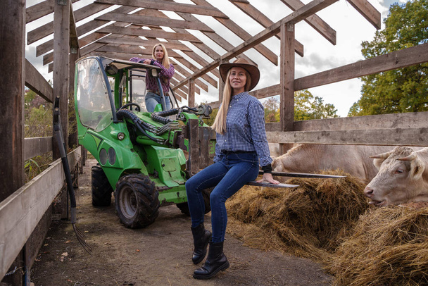 Portrait of happy farmers women with transportation and hay rolls. - Fotografie, Obrázek