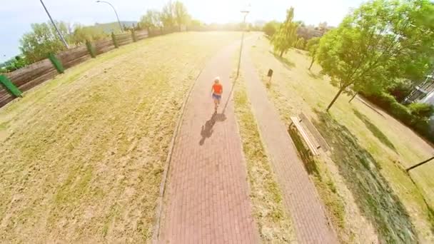 Veduta aerea drone al tramonto di una donna stile di vita jogging corsa all'aperto in un parco della città. Concetto di vita sana. stile di vita sano donna in abbigliamento sportivo in esecuzione nel parco al tramonto. - Filmati, video