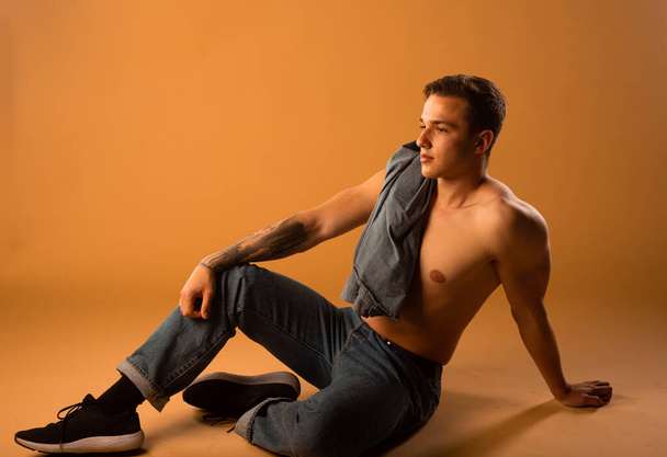 Torso záběr chladného mladého polonahého muže v džínách moderního stylu - Fotografie, Obrázek