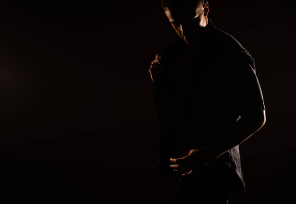 Silhouette of a handsome man standing in the studio - Photo, image
