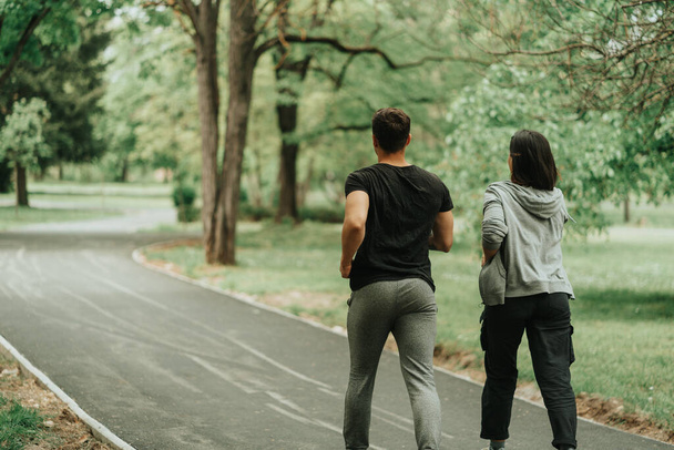 Крупный план пары, бегущей по дорожке в парке - Фото, изображение