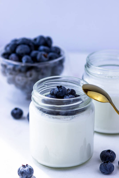 Homemade yogurt with blueberries. Yogurt in jars on a white background - Valokuva, kuva