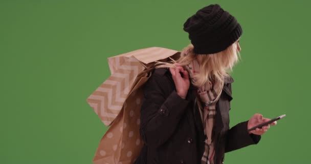Aranyos nő vár rideshare a bevásárló táskák a zöld képernyőn. Zöldfelületen karcolt vagy összeállított. - Felvétel, videó