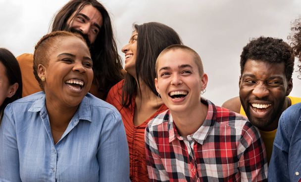 Gran grupo de amigos adultos jóvenes multirraciales divirtiéndose al aire libre y sonriendo - Foto, Imagen
