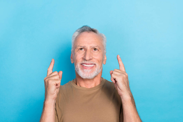 Portrait of attractive cheerful man raise two arm direct index empty space shopping sale discount isolated on blue color background. - Foto, afbeelding