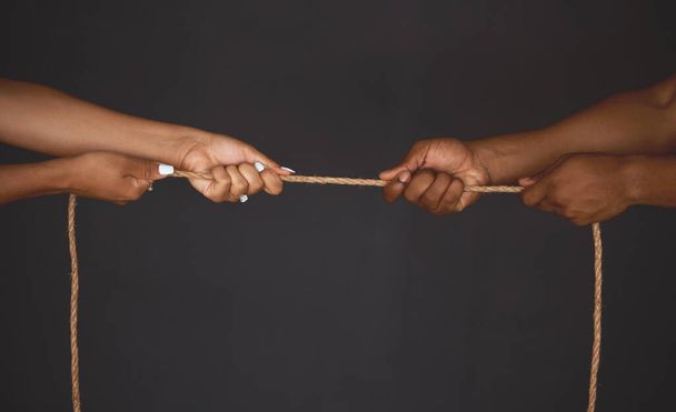 Tug of war, man and woman pulling rope in opposite direction for opposition, power and inequality in business. Competition and challenge with people hands in battle, struggle and fight for leadership. - Photo, Image