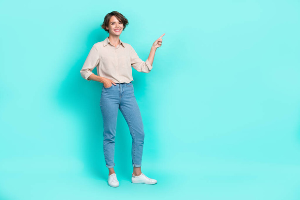 Full length photo of cheerful satisfied girl arm index present empty space recommend delivery service isolated on cyan color background. - Foto, Imagen